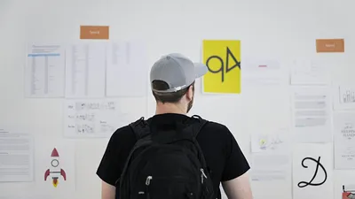 Designer looks at work variants on a large wall