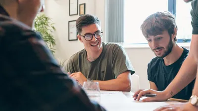 Mike smiles as Tom questions a wireframe
