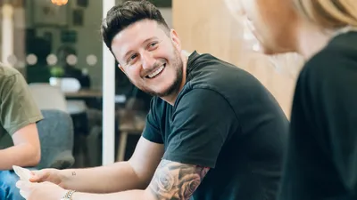 Andy Golpys smiling whilst playing cards with the MadebyShape team
