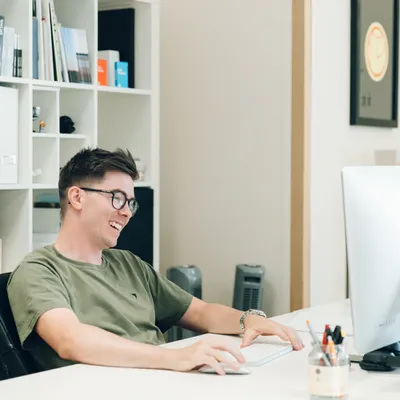 Mike laughs while sat at his desk