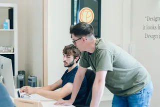 Mike and Tom go through some work at Toms desk