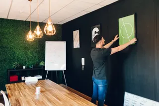 Andrew fixes a football print in the meeting room at MadeByShape